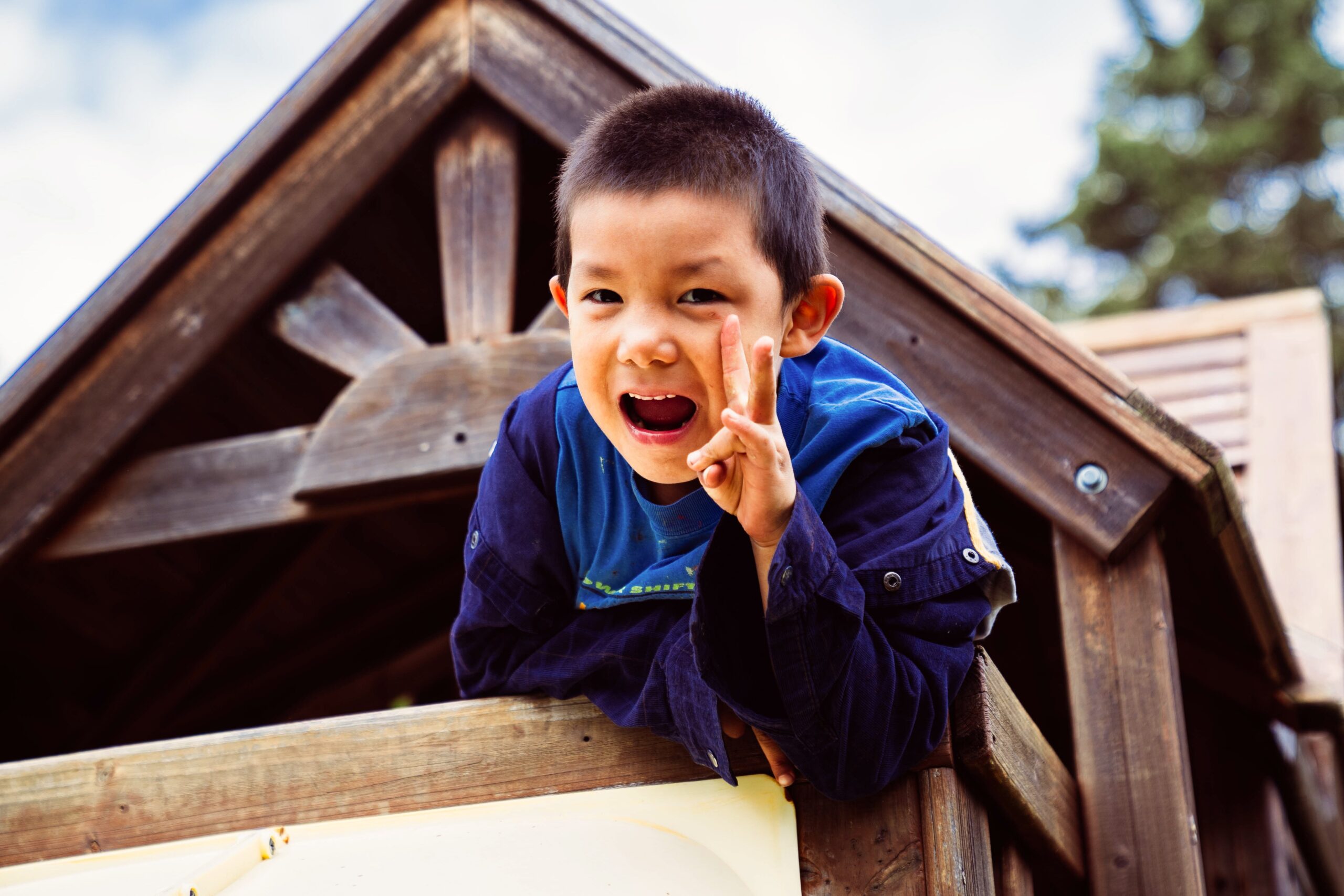Enfant jouant dans une structure en bois extérieure, illustrant les services offerts par les Centres d’amitié autochtone en milieu urbain.