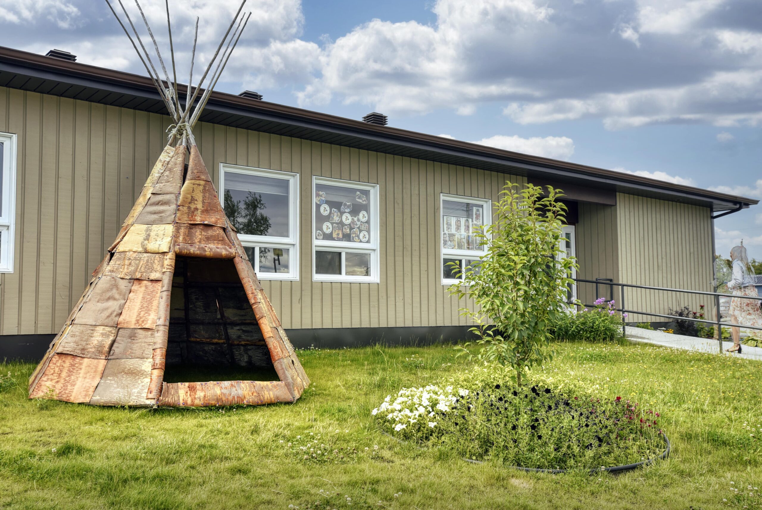 Façade du Centre d’entraide et d’amitié autochtone de Senneterre avec tipi traditionnel et aménagement paysager.