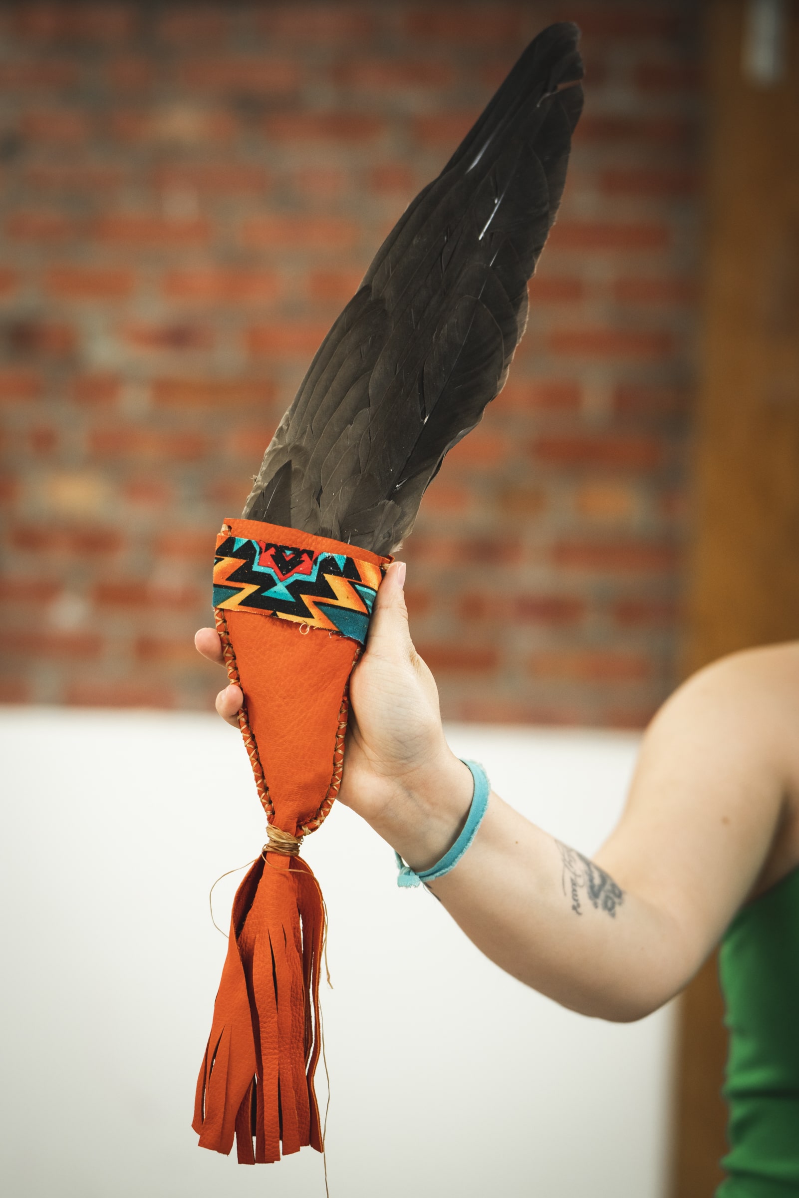 Fan traditionnel autochtone composé de plumes, d’un manche orné de tissus colorés à motifs autochtones.