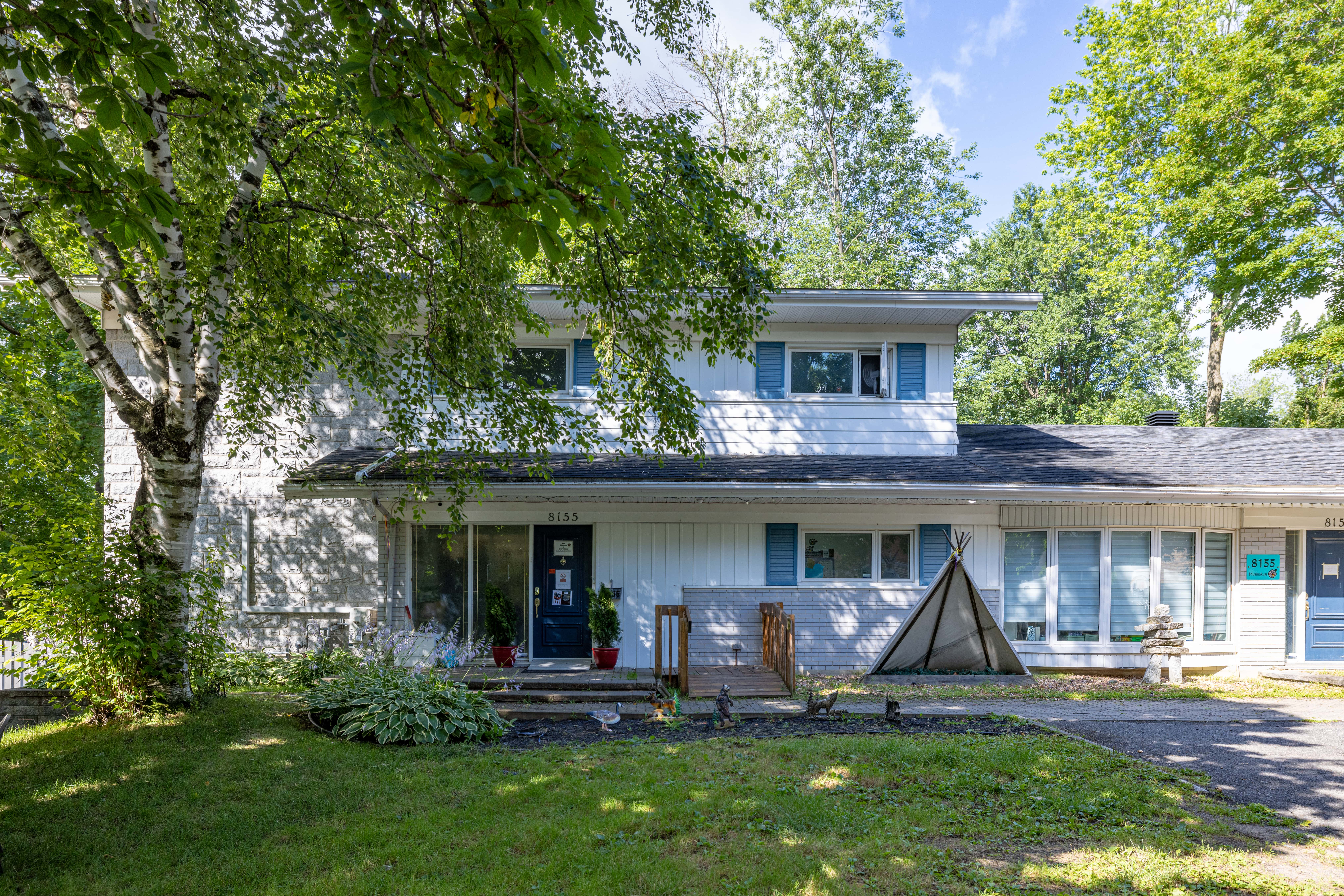Façade du Centre multi-services MAMUK à Québec avec éléments décoratifs et végétation environnante.