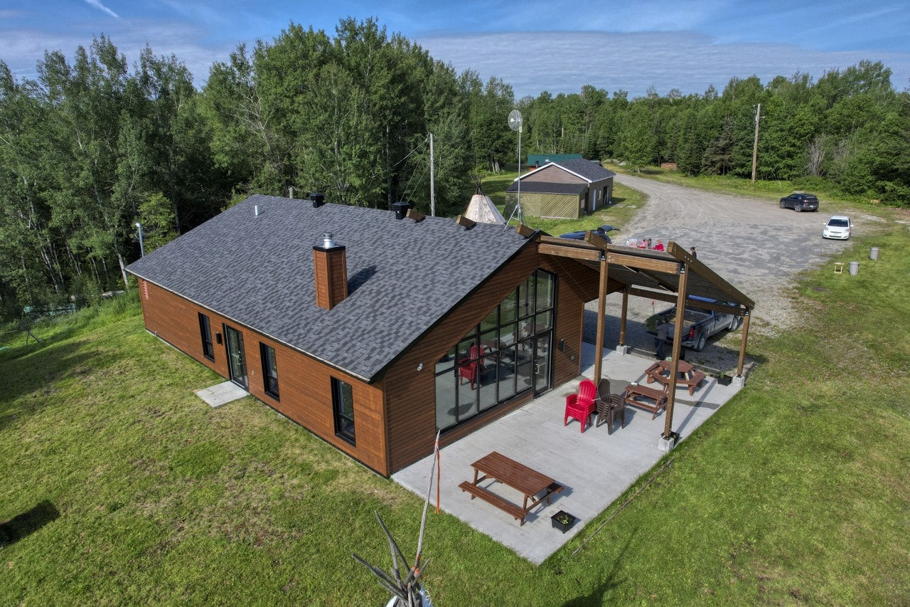 Bâtiment du site culturel Shabogamak avec terrasse aménagée, situé en milieu naturel à Senneterre.