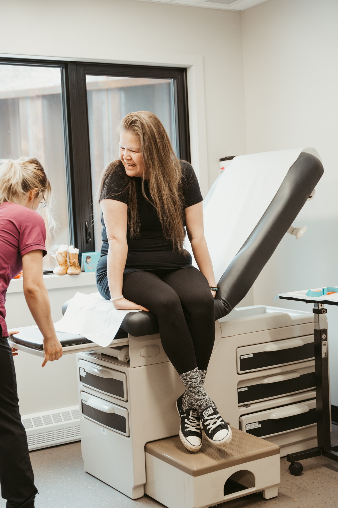 Consultation dans une clinique en santé autochtone d’un Centre d’amitié, avec une patiente assise sur la table d’examen et une infirmière préparant le matériel.