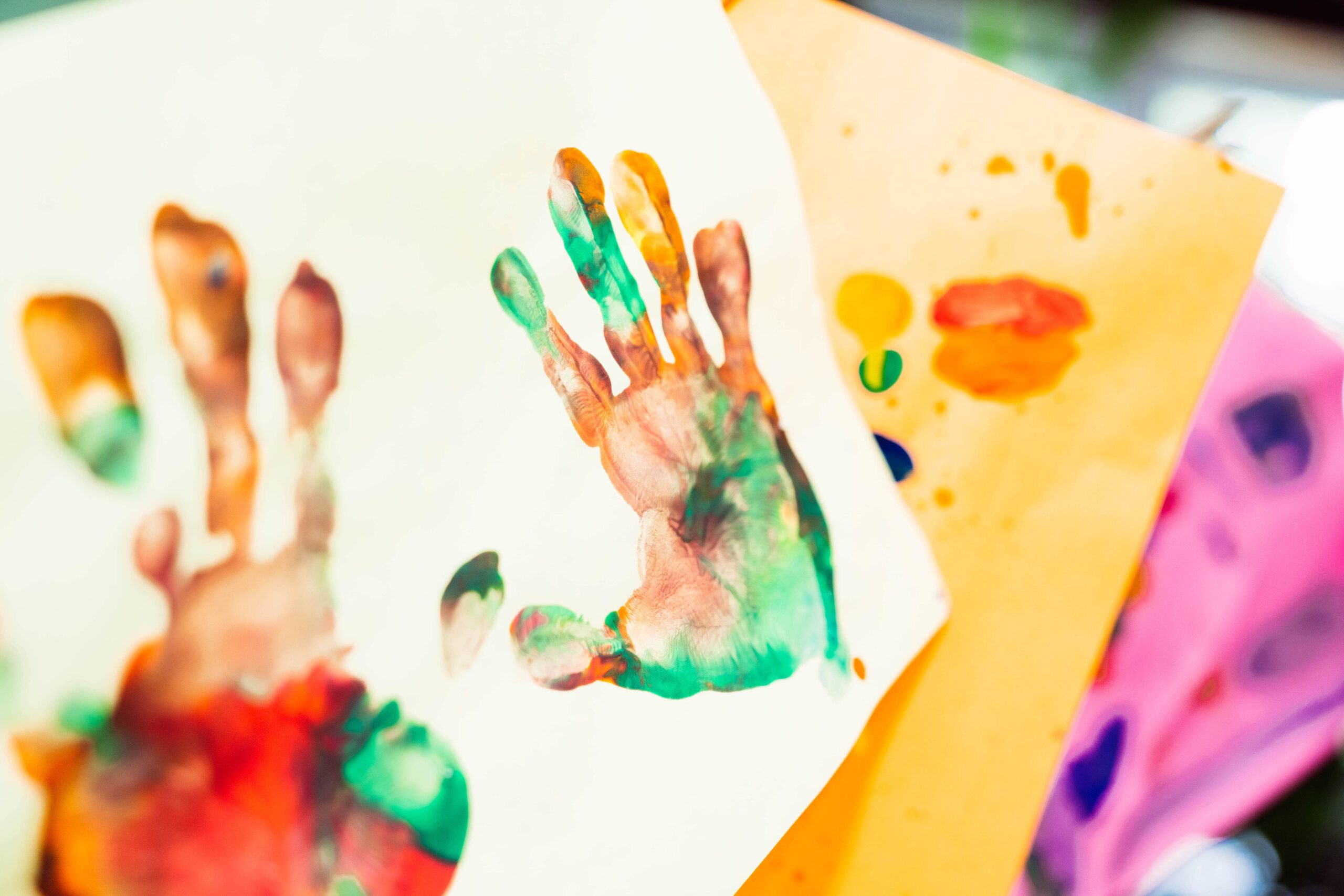 Empreintes de mains colorées réalisées en peinture sur papier lors d’un atelier créatif pour les enfants et familles fréquentant les Centres d'amitié.