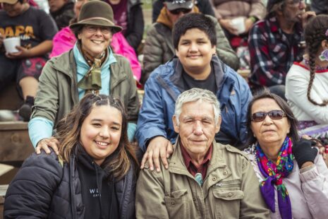 Groupe de personnes assises côte à côte lors d’un rassemblement en extérieur